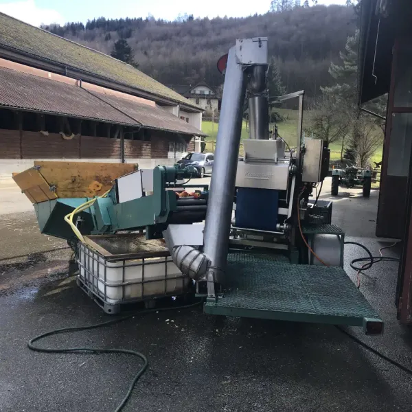 Mobile Bandpresse von der Rückseite betrachtet mit ersichtlichen Wasseranschlüssen und Antriebseinheit